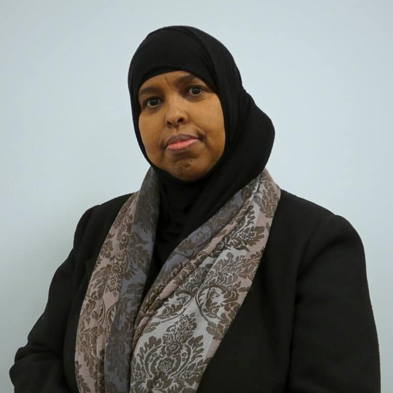 May contain a person wearing a black hijab and a patterned scarf.