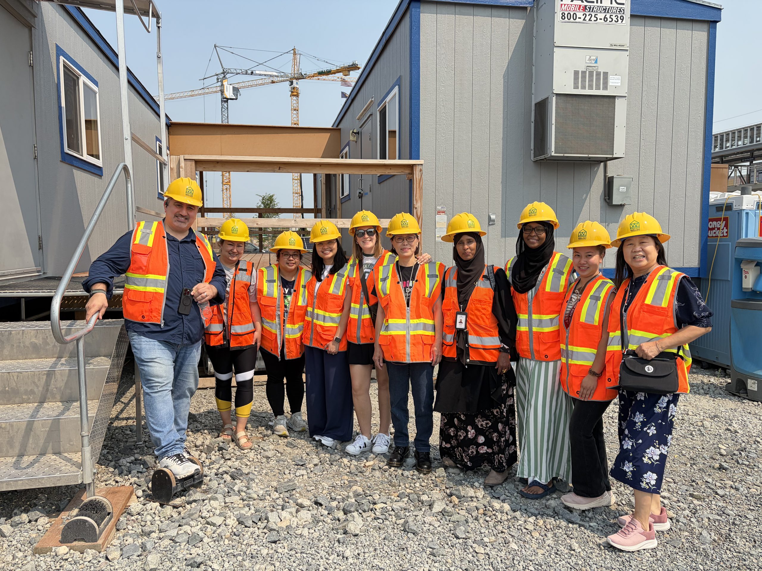 May contain ten people wearing yellow hard hats and orange vests.