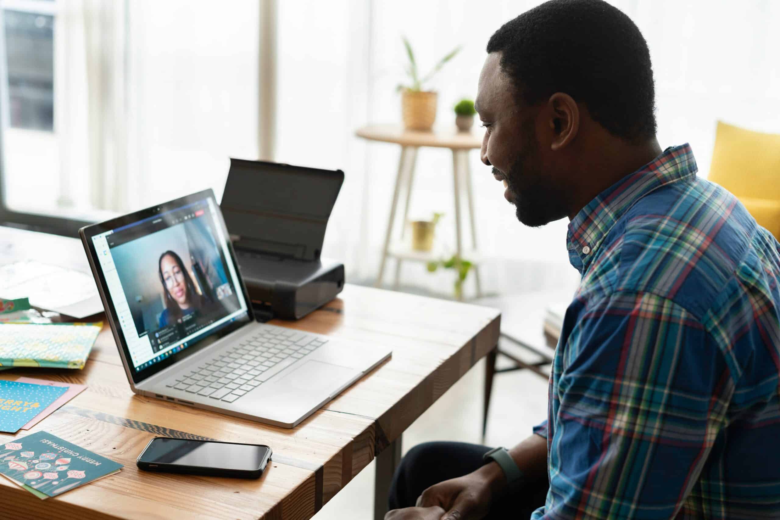 May contain two people in a video call, one person looking at laptop.